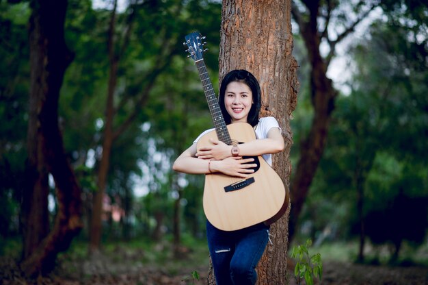 Donna con la sua chitarra che canta in natura