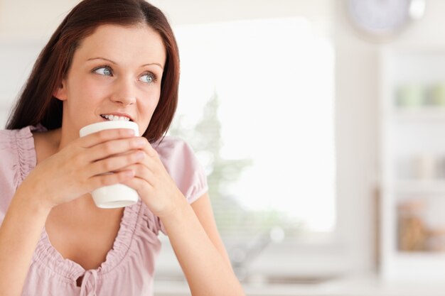 Donna con la tazza di caffè guardando lontano