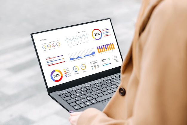 Donna con laptop e grafici finanziari un grafico di analisi e statistiche sullo schermo