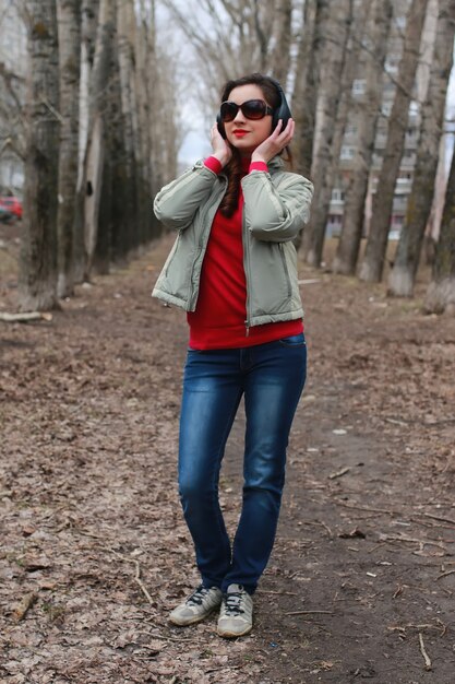 Donna con le cuffie nel parco autunno