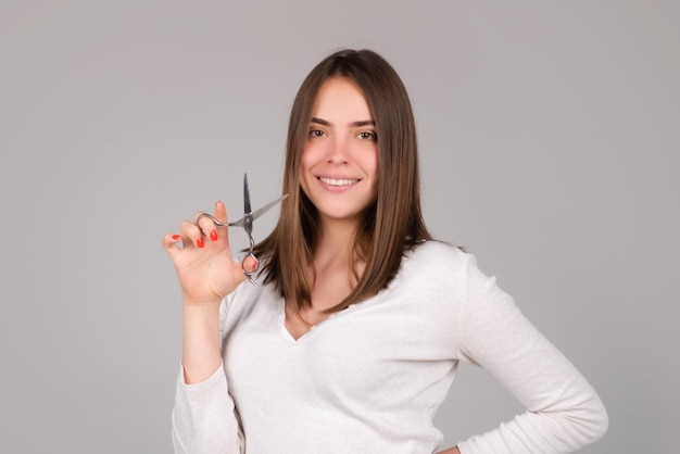 Donna con le forbici che hanno tagliato i capelli bella ragazza con i capelli lisci con una forbice professionale