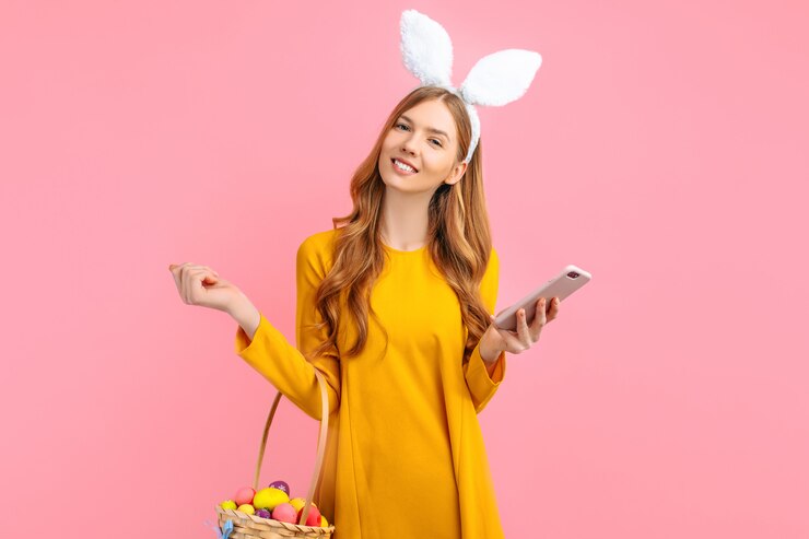 Donna con le orecchie del coniglietto che tiene un telefono