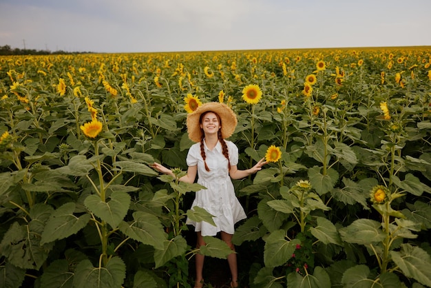 Donna con le trecce alla ricerca nel campo di girasole Ora legale