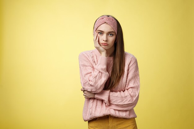 Donna con maglione rosa su giallo