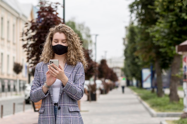 Donna con maschera di controllo all'aperto mobile