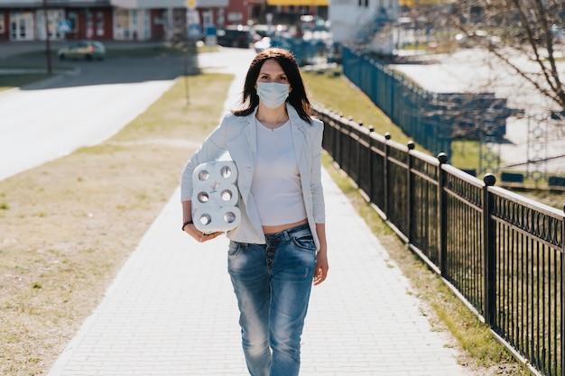 Donna con maschera medica con rotoli di carta igienica