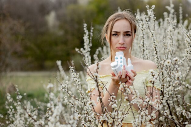 Donna con medicina allergica nel campo fiorito