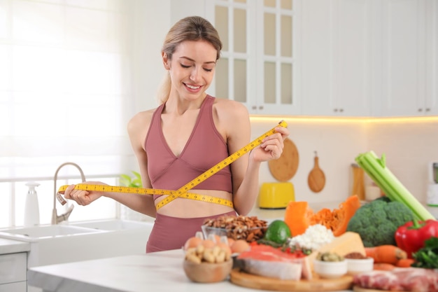 Donna con metro a nastro e diversi prodotti in cucina Dieta Keto