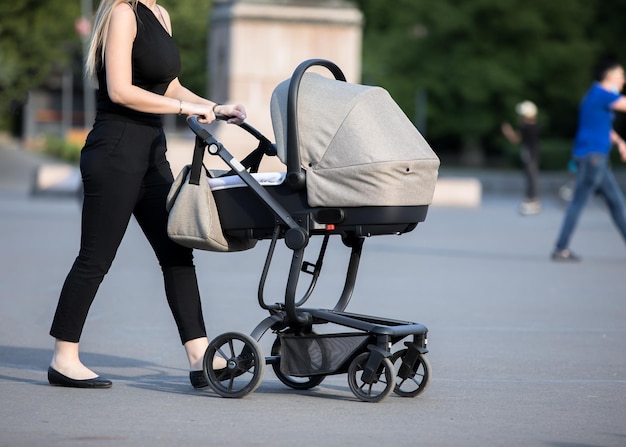 Donna con passeggino che cammina lungo la streetxA