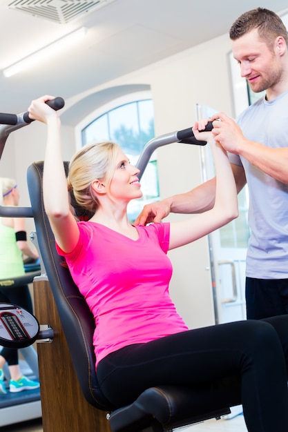 Donna con personal trainer facendo sport in palestra