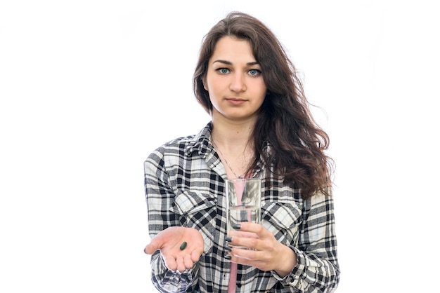 Donna con pillole e bicchiere d'acqua isolato su bianco