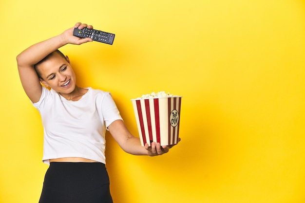 Donna con popcorn e TV concetto di home cinema remoto