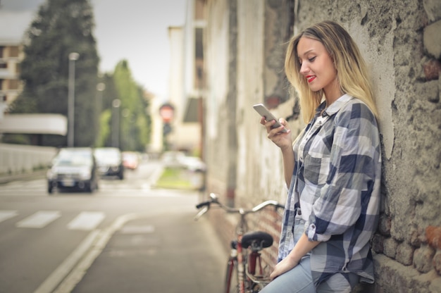 donna con smartphone e bici