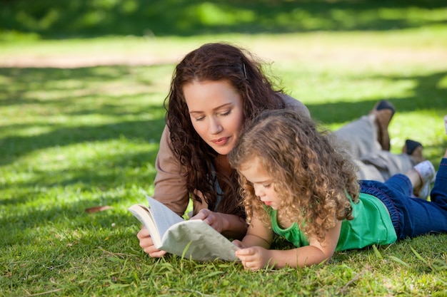 Donna con sua figlia leggendo un libro