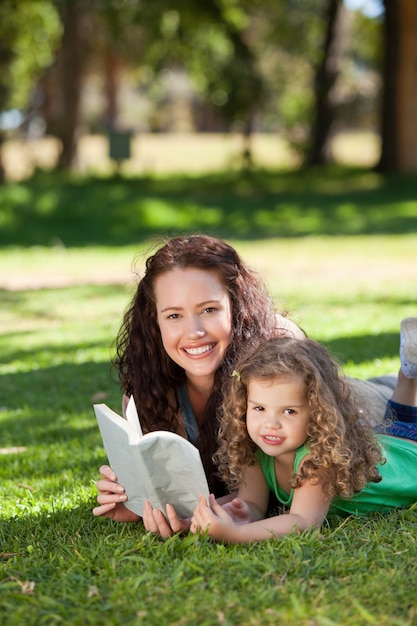 Donna con sua figlia leggendo un libro