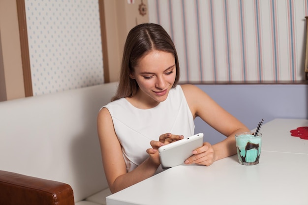 Donna con tablet e bevande nella caffetteria