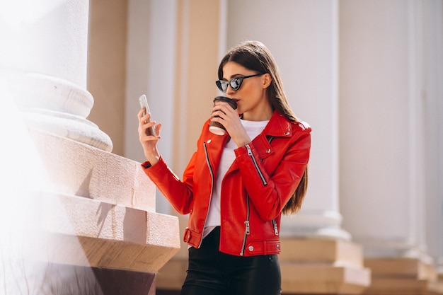 Donna con telefono e caffè