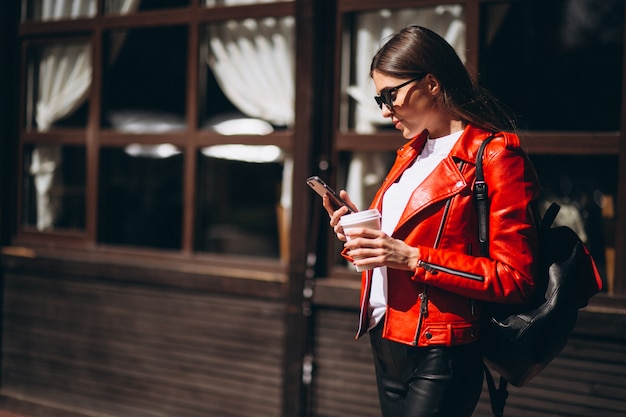 Donna con telefono e caffè