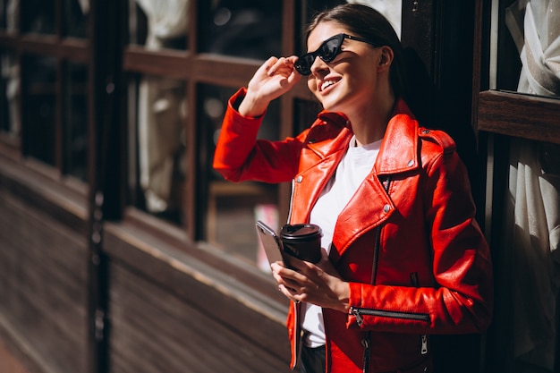 Donna con telefono e caffè