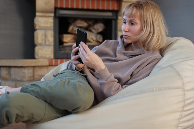 Donna con telefono sul divano