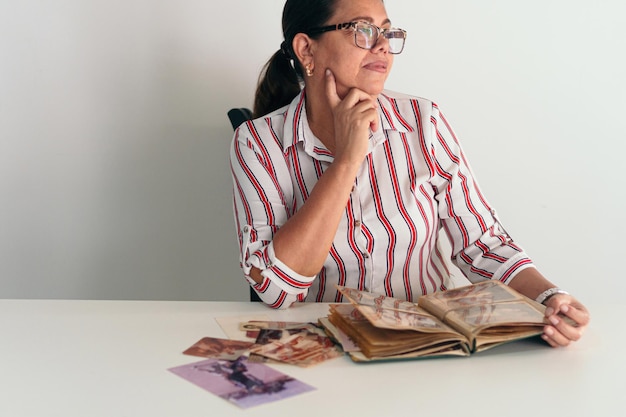 Donna con un album di foto nel soggiorno di casa sua