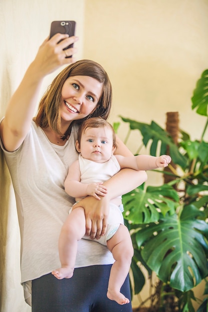 Donna con un bambino che fa un selfie a casa tua