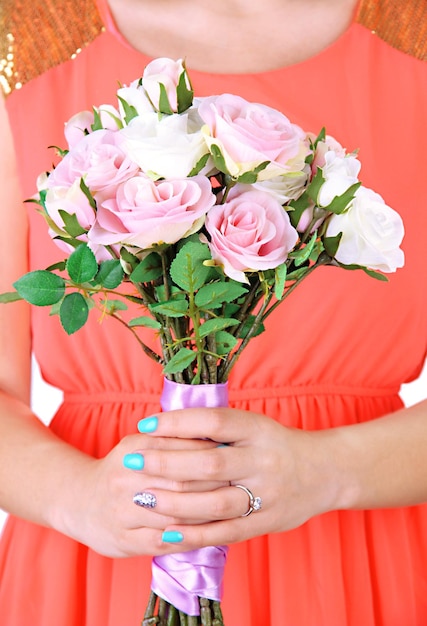 Donna con un bouquet di rose su uno sguardo ravvicinato sullo sfondo luminoso