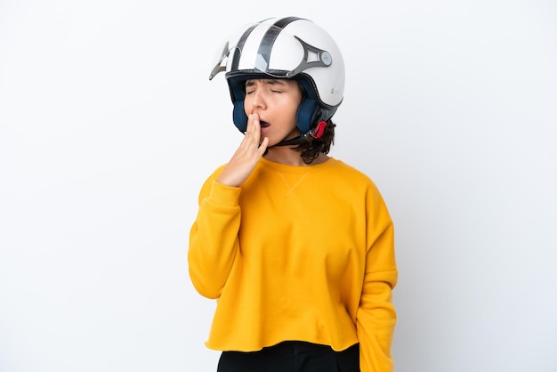 Donna con un casco da motociclista che sbadiglia e copre la bocca spalancata con la mano