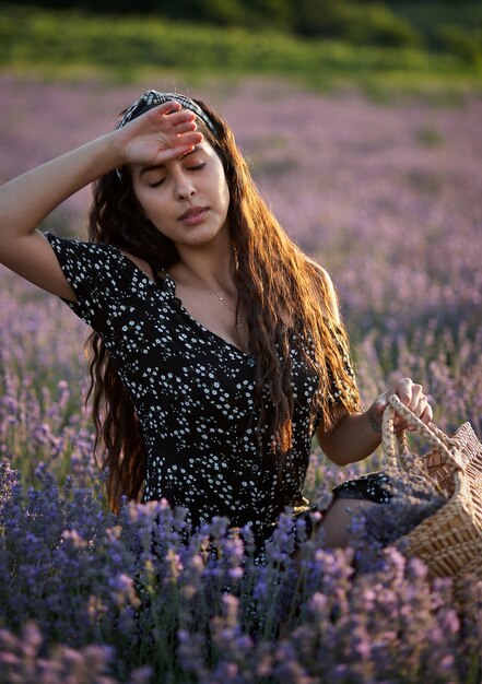 Donna con un cesto in un campo di lavanda