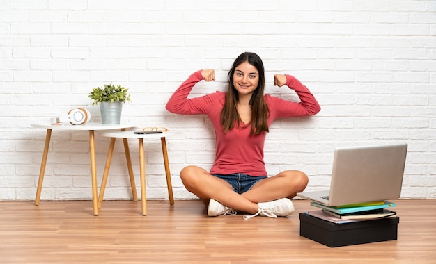 Donna con un computer portatile seduto sul pavimento