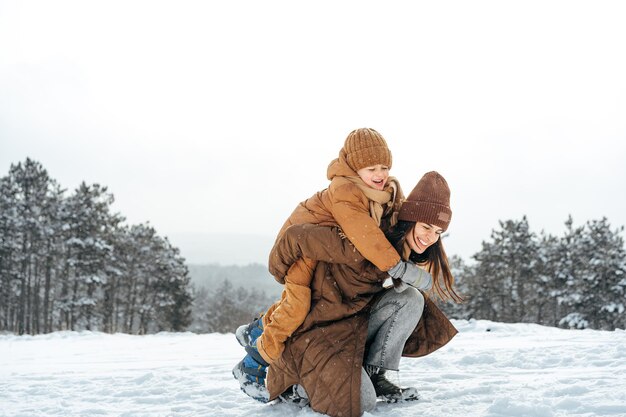 Donna con un figlio piccolo durante un'escursione invernale nella foresta innevata