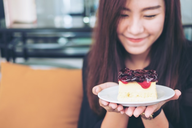 donna con un pezzo di torta di formaggio ai mirtilli