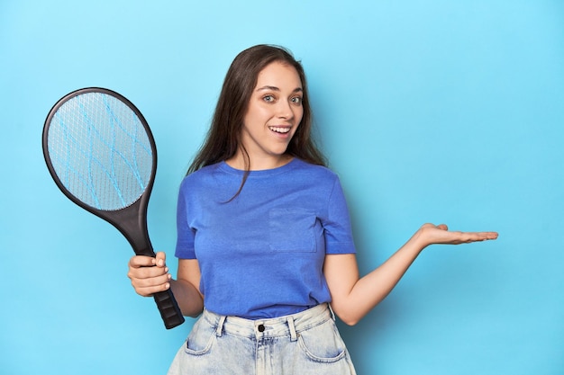 Donna con un zapper elettrico su uno sfondo blu che mostra uno spazio di copia su un palmo