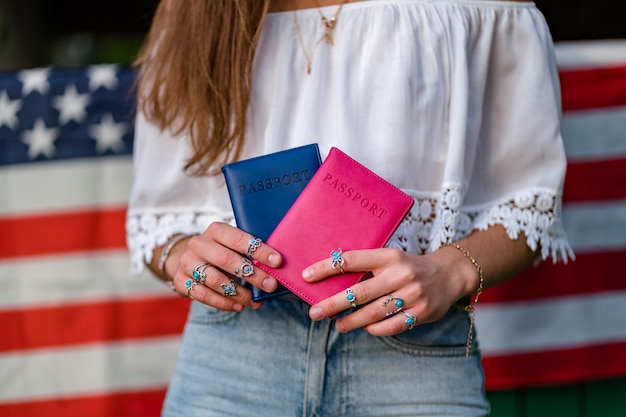 Donna con una bandiera americana e passaporti nelle sue mani