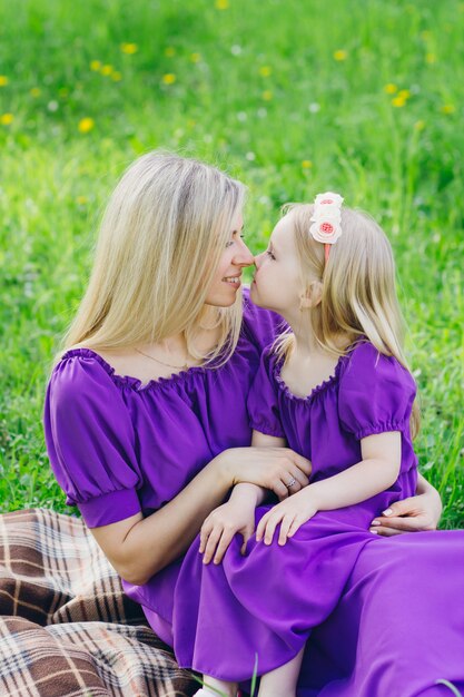 Donna con una figlia piccola che cammina attraverso la fioritura di Apple