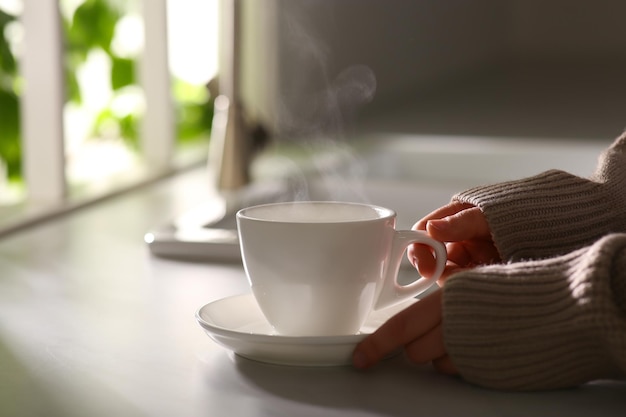 Donna con una tazza di caffè gustoso a casa primo piano Buongiorno