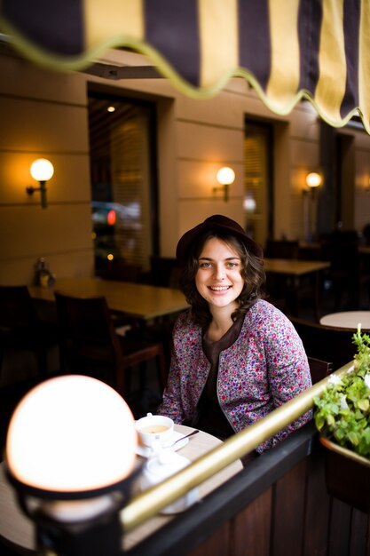 Donna con una tazza di tè seduti in un caffè.