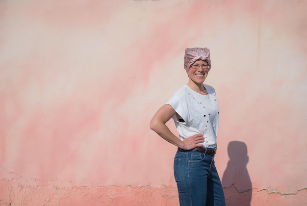 Donna con velo rosa che combatte il cancro su una parete colorata