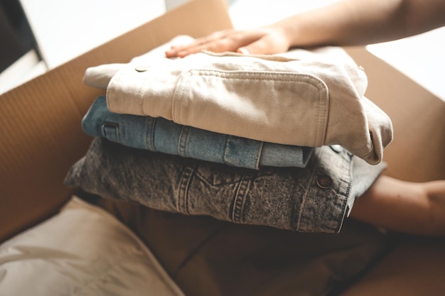 Donna con vestiti con scatola di donazione nella sua stanza