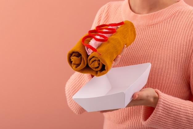 Donna con vista laterale che tiene il cibo fatto di vestiti