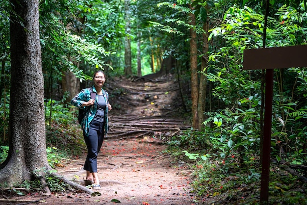 Donna con zaino che esplora la bellissima foresta pluviale su Sub madue Petchabun Thailandia Concetto di viaggio ed ecoturismo