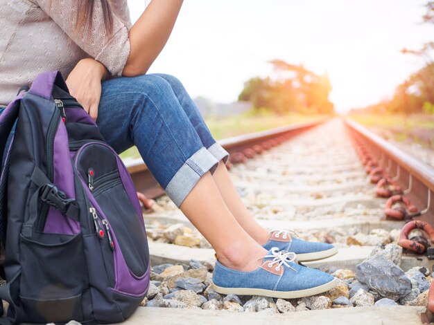 Donna con zaino sulla piattaforma ferroviaria. Concetto di viaggio e di vacanza