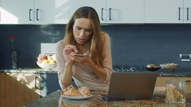 Donna concentrata che fa foto al telefono cellulare Donna seria che prende foto dell'alimento