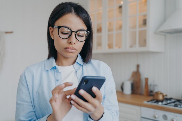 Donna concentrata che invia messaggi e consulta online o utilizza l'applicazione Lavoro a distanza in quarantena