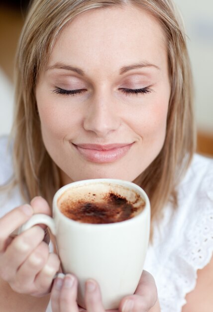 Donna contentissima che beve un caffè