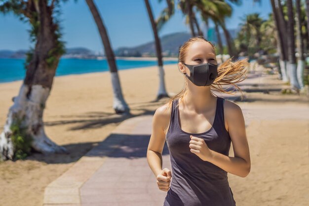 Donna corridore che indossa una maschera medica che corre nel parco pandemia di coronavirus covid sport vita attiva