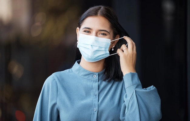 Donna covid e maschera facciale rimozione per la fine della libertà pandemica nella sicurezza sanitaria sul mockup Ritratto di donna che si toglie la maschera protettiva in rilievo per il virus corona che termina su sfondo bokeh