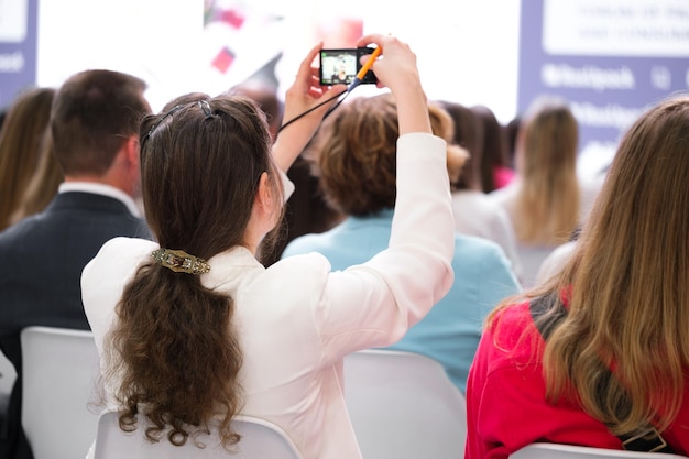 Donna d'affari a una conferenza di lavoro o presentazione o tiro di formazione video sullo smartphone