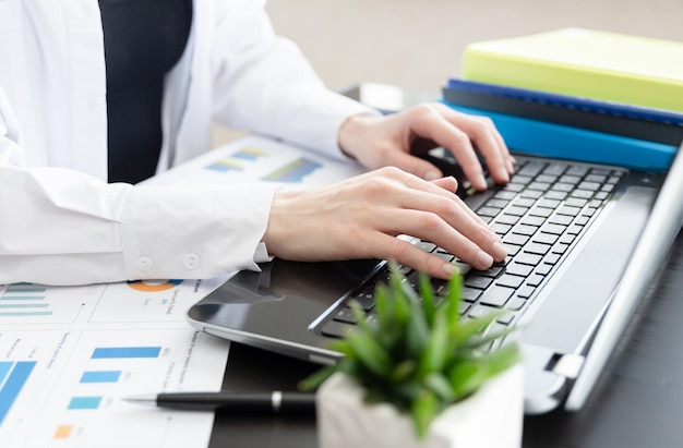 Donna d'affari al lavoro Vista in primo piano della donna che lavora al computer portatile mentre è seduto alla scrivania in legno