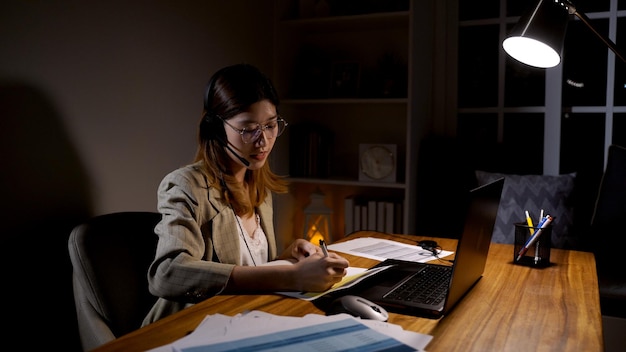 Donna d'affari asiatica che lavora online di notte. Occupato ed esausto dal lavoro straordinario a casa